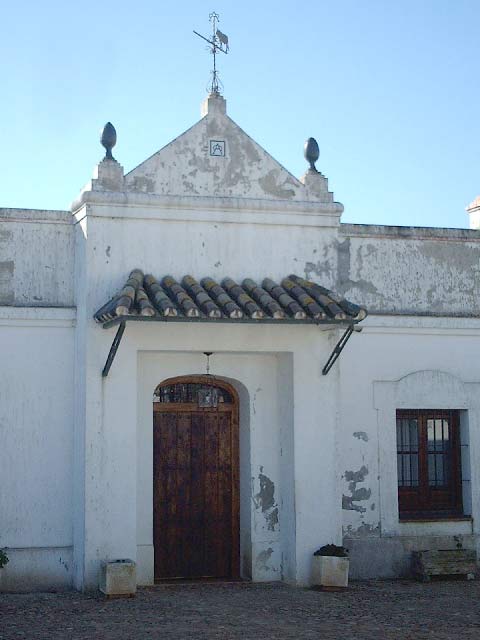 La fachada del cortijo coronada por el hierro y el toro de Miura.