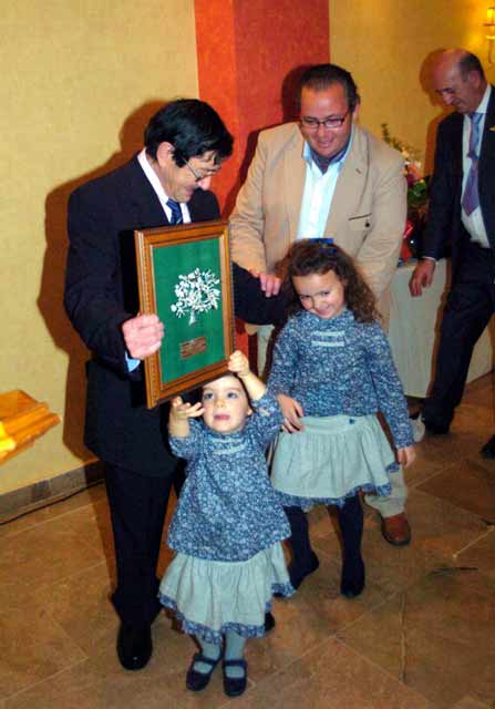 Sus dos nietas haciéndole entrega de otro regalo.