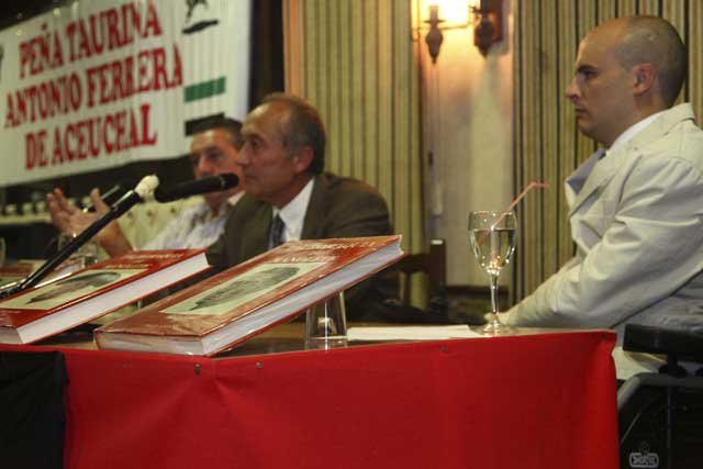 Francisco Laguna dirigiéndose al auditorio escoltado por su libro sobre Manolete