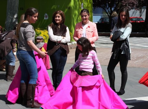 La alumna Olga Sánchez explicando a una niña como se coge el capote.