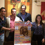 Los tres actuantes junto con el alcalde de Táliga posando con el cartel del festival