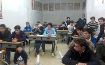 Los niños de la escuela junto a su maestro Luis Reina atentos a las explicaciones de Tomás Martínez
